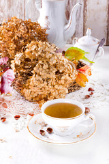 Tea in the rustic vintage Chic style. Garden tea Party. Teapot of dry flowers. Cup of tea with autumn decor on table, with hydrangea and pumpkin