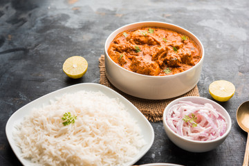 Murgh Makhani / Butter chicken tikka masala served with roti / Paratha and plain rice along with onion salad. selective focus