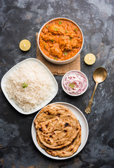 Murgh Makhani / Butter chicken tikka masala served with roti / Paratha and plain rice along with onion salad. selective focus