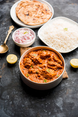Murgh Makhani / Butter chicken tikka masala served with roti / Paratha and plain rice along with onion salad. selective focus