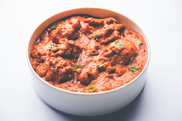 Murgh Makhani / Butter chicken tikka masala served with roti / Paratha and plain rice along with onion salad. selective focus