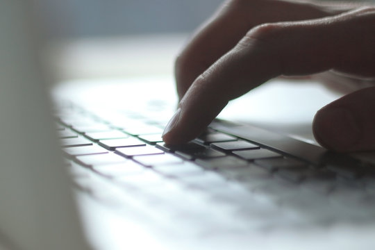 close up. blurred image of male typing on laptop keyboard