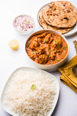 Murgh Makhani / Butter chicken tikka masala served with roti / Paratha and plain rice along with onion salad. selective focus