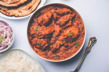 Murgh Makhani / Butter chicken tikka masala served with roti / Paratha and plain rice along with onion salad. selective focus
