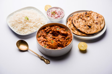 Murgh Makhani / Butter chicken tikka masala served with roti / Paratha and plain rice along with onion salad. selective focus