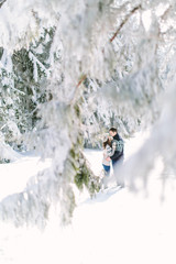 christmas happy couple in love embrace in snowy winter cold forest, copy space, new year party celebration, holiday and vacation, travel, love and relations