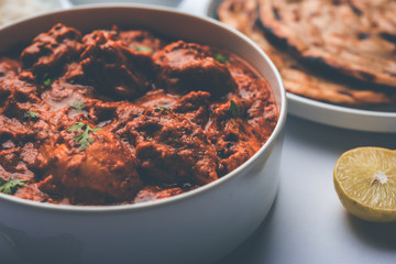 Murgh Makhani / Butter chicken tikka masala served with roti / Paratha and plain rice along with onion salad. selective focus