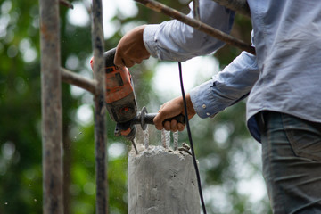 Workers are using Impact drill to drill concrete..