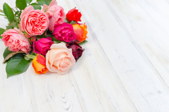 Valentines day background with colorful fresh roses laying on white table.