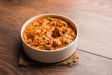 Murgh Makhani / Butter chicken tikka masala served with roti / Paratha and plain rice along with onion salad. selective focus