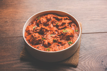 Murgh Makhani / Butter chicken tikka masala served with roti / Paratha and plain rice along with onion salad. selective focus