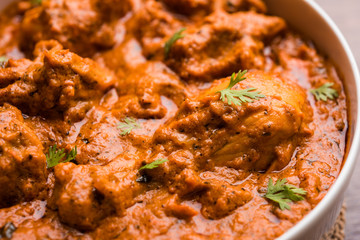Murgh Makhani / Butter chicken tikka masala served with roti / Paratha and plain rice along with onion salad. selective focus