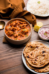 Murgh Makhani / Butter chicken tikka masala served with roti / Paratha and plain rice along with onion salad. selective focus