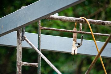 Electrode Holder is hung on a railing on a rainy day.