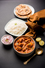 Murgh Makhani / Butter chicken tikka masala served with roti / Paratha and plain rice along with onion salad. selective focus