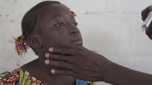 A young African girl gets her oral vaccine. Diseases such as dengue fever, malaria, diarrhea are a huge problem for African countries. 4K RAW clip, please modify and edit (color grade, stabilize, etc.