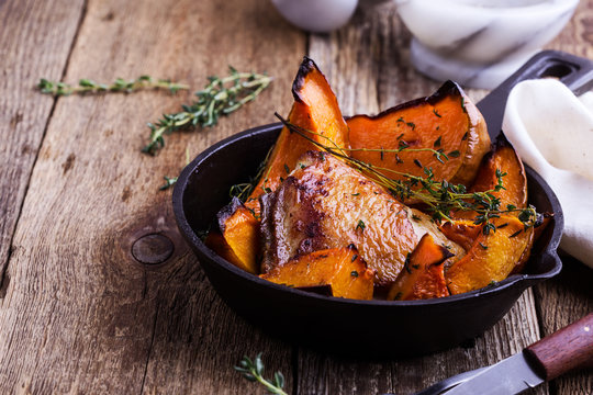 Roasted chicken thighs with sliced butternut squash pumpkin and fresh thyme
