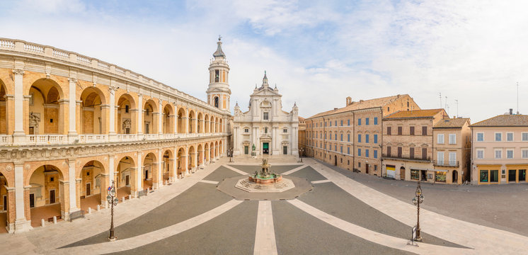 Square of Loreto, Basilica della Santa Casa in sunny day, portico to the side, people in the square in Loreto in Ancona, Italy
