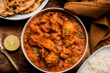 Murgh Makhani / Butter chicken tikka masala served with roti / Paratha and plain rice along with onion salad. selective focus