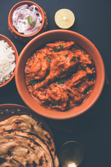 Murgh Makhani / Butter chicken tikka masala served with roti / Paratha and plain rice along with onion salad. selective focus