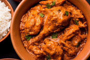 Murgh Makhani / Butter chicken tikka masala served with roti / Paratha and plain rice along with onion salad. selective focus