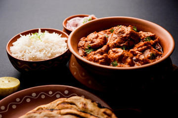 Murgh Makhani / Butter chicken tikka masala served with roti / Paratha and plain rice along with onion salad. selective focus