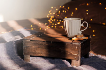 White cup of coffee on the bed and lights