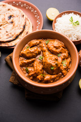 Murgh Makhani / Butter chicken tikka masala served with roti / Paratha and plain rice along with onion salad. selective focus