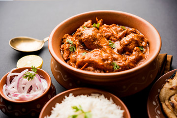 Murgh Makhani / Butter chicken tikka masala served with roti / Paratha and plain rice along with onion salad. selective focus