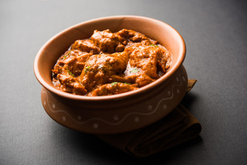 Murgh Makhani / Butter chicken tikka masala served with roti / Paratha and plain rice along with onion salad. selective focus