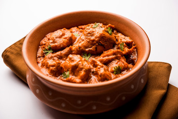 Murgh Makhani / Butter chicken tikka masala served with roti / Paratha and plain rice along with onion salad. selective focus