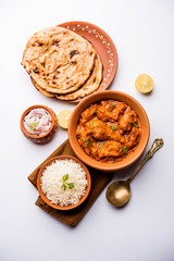 Murgh Makhani / Butter chicken tikka masala served with roti / Paratha and plain rice along with onion salad. selective focus