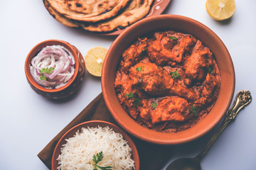 Murgh Makhani / Butter chicken tikka masala served with roti / Paratha and plain rice along with onion salad. selective focus