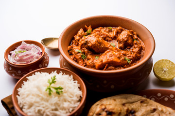 Murgh Makhani / Butter chicken tikka masala served with roti / Paratha and plain rice along with onion salad. selective focus