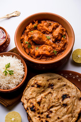 Murgh Makhani / Butter chicken tikka masala served with roti / Paratha and plain rice along with onion salad. selective focus