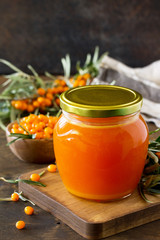 Fresh Sea Buckthorn Berries and Fruit Syrup Sea Buckthorn on a wooden rustic background. Copy space.
