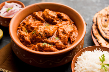 Murgh Makhani / Butter chicken tikka masala served with roti / Paratha and plain rice along with onion salad. selective focus