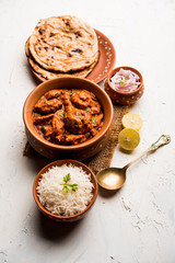 Murgh Makhani / Butter chicken tikka masala served with roti / Paratha and plain rice along with onion salad. selective focus