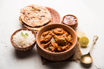 Murgh Makhani / Butter chicken tikka masala served with roti / Paratha and plain rice along with onion salad. selective focus