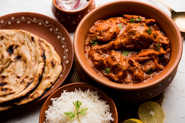 Murgh Makhani / Butter chicken tikka masala served with roti / Paratha and plain rice along with onion salad. selective focus