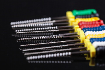 dental and endodontic restoration instruments on a black dark background. Top view