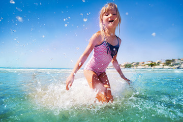 Adorable little girl having fun at shallow water