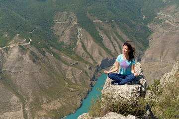 Naklejka na ściany i meble Sulak canyon in Dagestan, one of the deepest in the world. The woman enjoys the view of the canyon and the turquoise river Sulak.