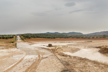 Cut road by muddy flood after historic storm in Seville and Málaga that caused the overflow of rivers and streams
