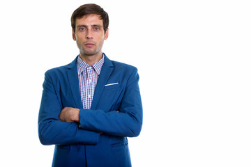 Studio shot of young handsome businessman with arms crossed
