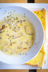 mushroom cream soup with mushrooms, herb and garlic toast on the side