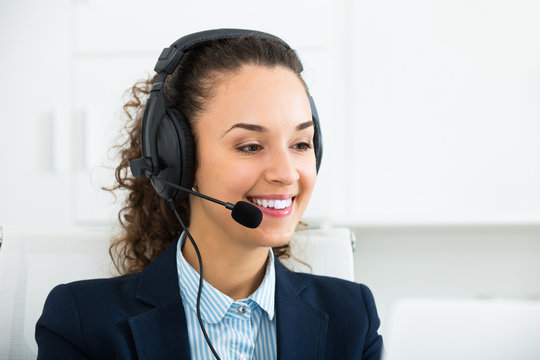 Happy woman operator talking with client by headset