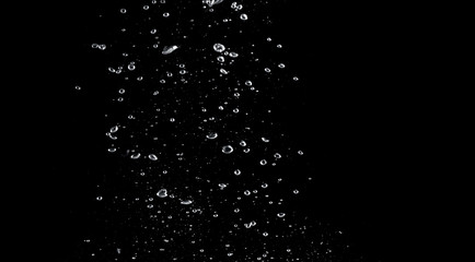 Naklejka na ściany i meble Blurred images of close-up soda water bubbles fizzing up or splashing or sparkling like a exploding of a bomb on black background for represent refreshing from carbonated drinks menu.
