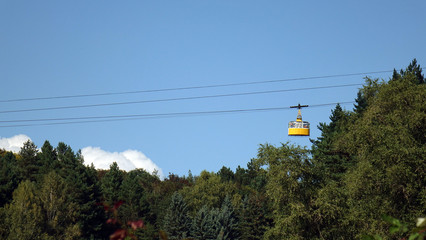 Funicular down from the top of the mountain to the city below. Green pine forest on the mountainside. Tourist tour.