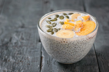 Chia seed pudding bowl with peaches, bananas and pumpkin seeds.